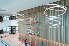 01.06.2023: Blick von der Galerie ins Parkettgeschossfoyer mit den großen Hängeleuchten unter der Decke. Auf der Saalrückseite werden Lichtleisten installiert.