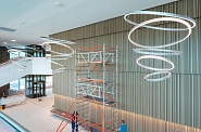 01.06.2023: Blick von der Galerie ins Parkettgeschossfoyer mit den großen Hängeleuchten unter der Decke. Auf der Saalrückseite werden Lichtleisten installiert.