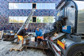 06.10.2022: Gussasphalt wird in Eimer abgefüllt und per Transportband ins Gebäude hochgefahren