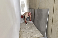 10.11.2022: Im Lüftungskanal unter der Terrasse werden Gipsplatten zur Begehung auf die feuchtigkeitsregulierende Bodendämmung geklebt
