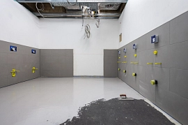 15.09.2022: in einem der Toilettenräume im Erdgeschoßfoyer sind die Wände gefliest worden; auf dem Boden wird Haftgrund für die Fliesen aufgetragen