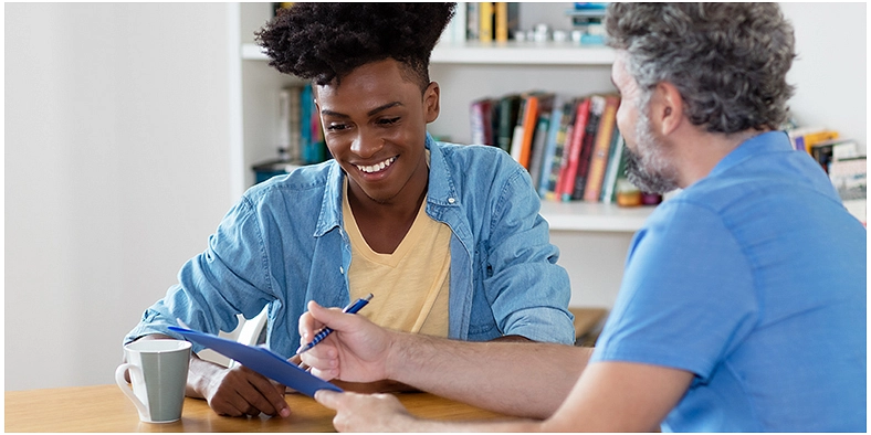 Flüchtlingsarbeit Flüchtlingsarbeit - zwei Personen sitzen an einem Tisch und schauen auf ein Schriftstück © Daniel Ernst, stock.adobe.com